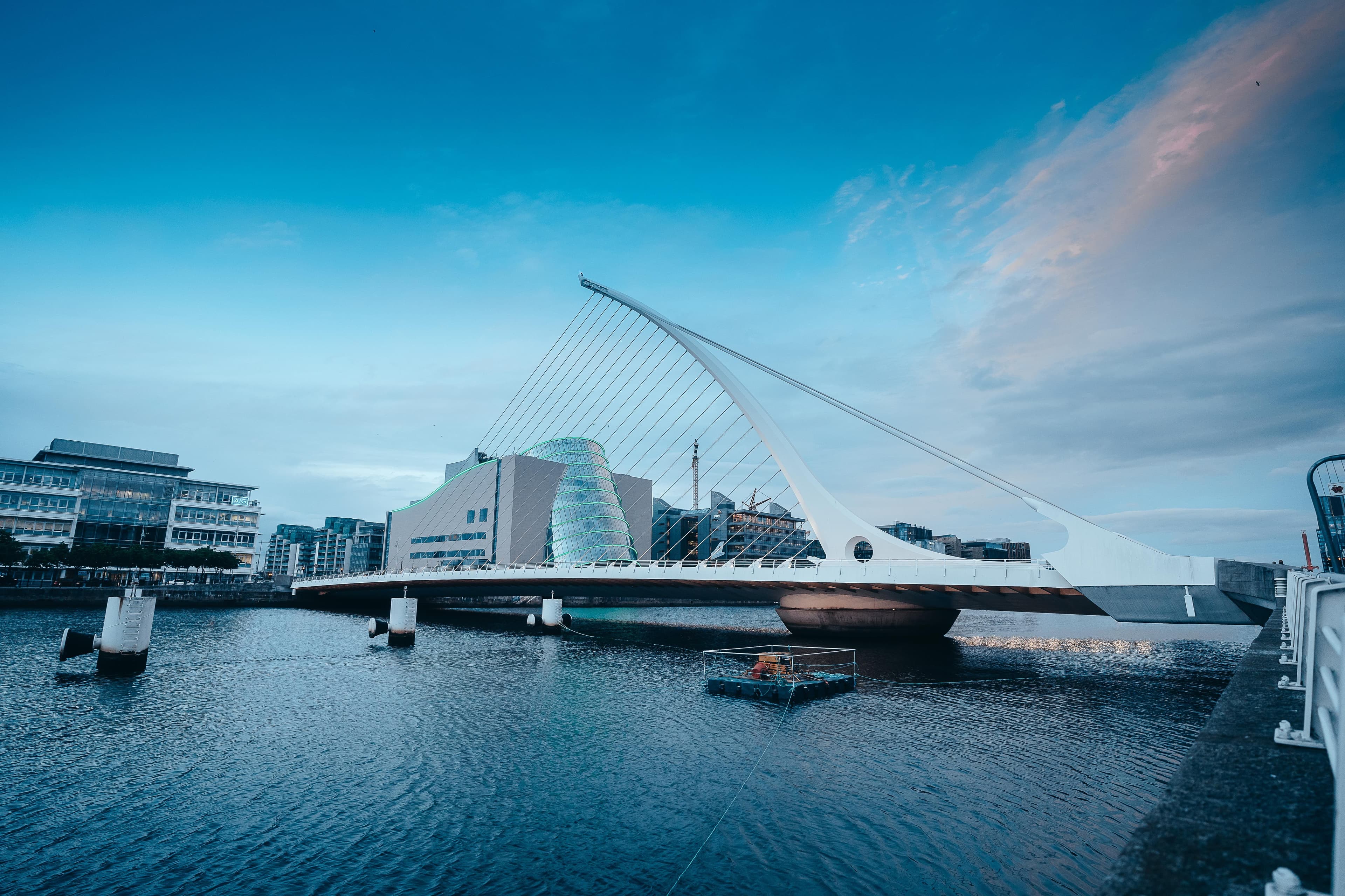 The Samuel Beckett Bridge and the Convention Centre on the River Liffey in Dublin's docklands under a blue sky.